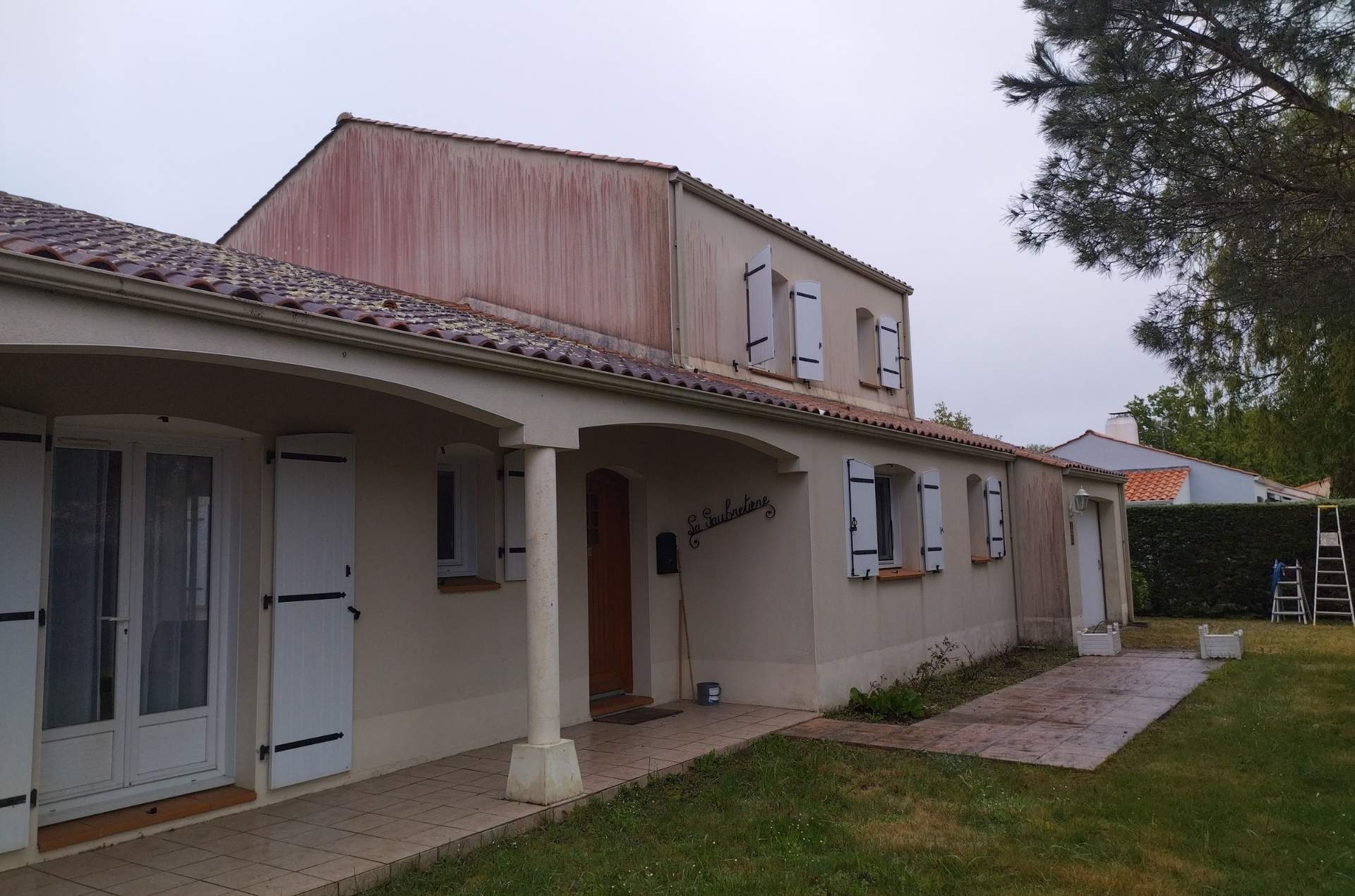 Façade encrassée à Saint-Urbain avant nettoyage – traces algaires et ruissellements rougeâtres