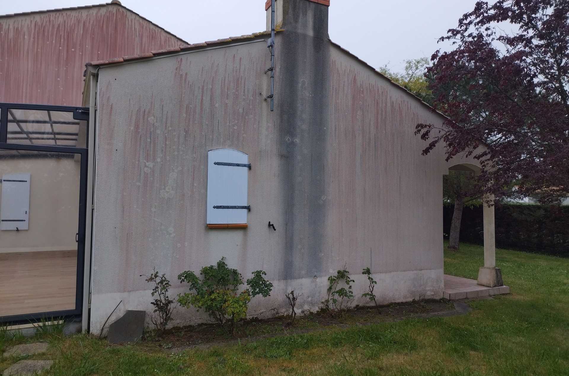 Traces noires le long de la cheminée et ruissellements sur façade avant nettoyage à Saint-Urbain