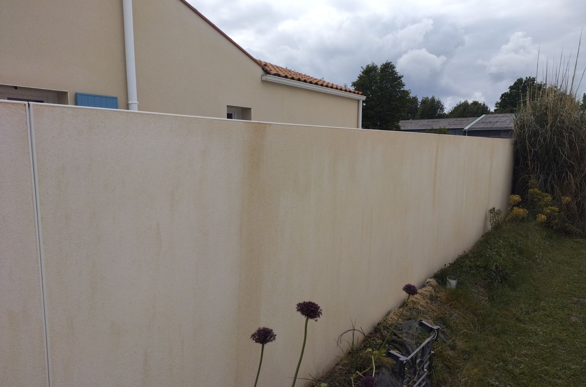 Clôture extérieure nettoyée après intervention Mur de clôture propre après nettoyage extérieur